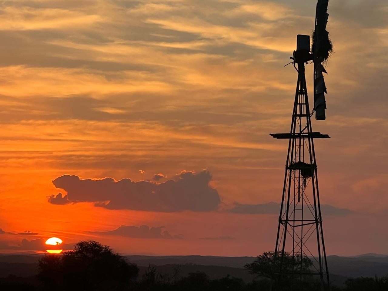 A windmill silhouetted against a glowing sunset